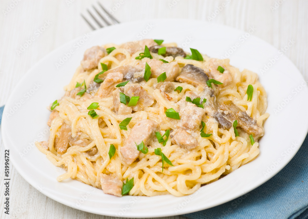 Spaghetti with meat and mushrooms in a creamy sauce