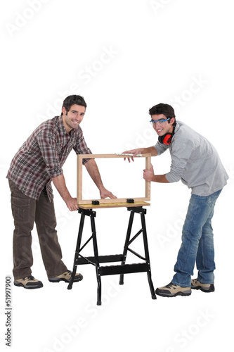 Tradesmen building a wooden frame