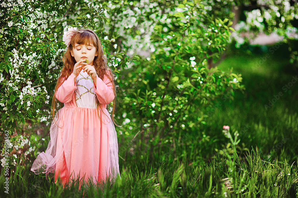 Fototapeta premium beautiful little girl in a spring garden