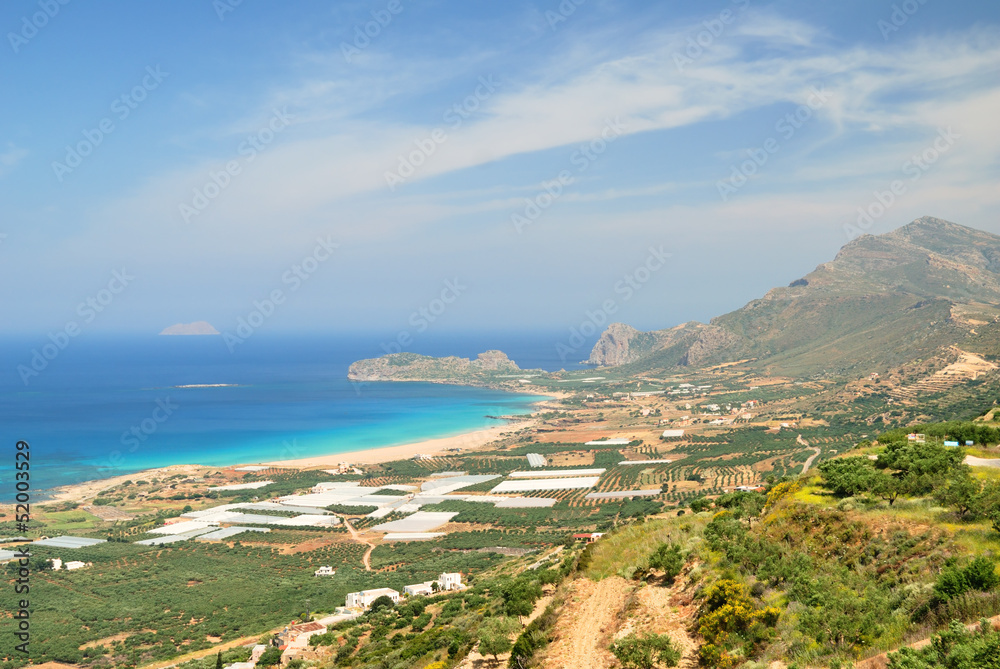 Mountain above a sandy beach and blue sea on Crete