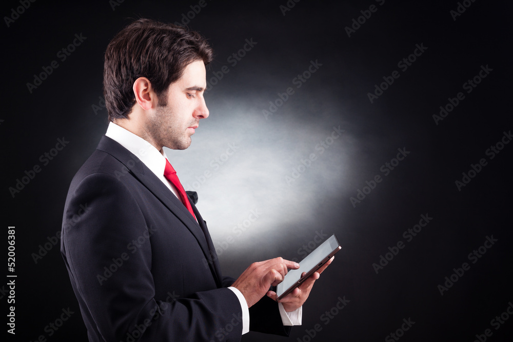 Handsome business man with tablet computer against black backgro Handsome business man with tablet computer against black backgro