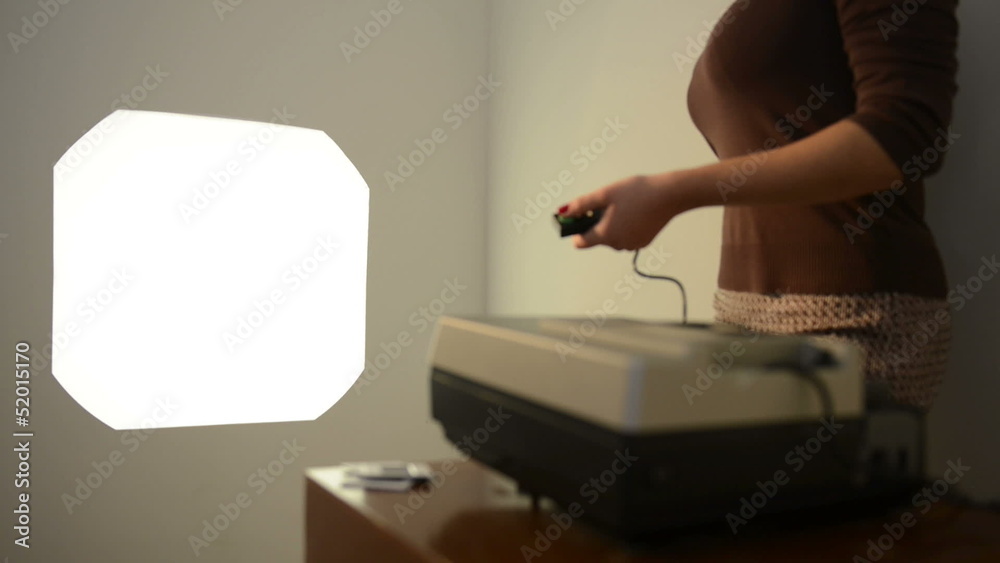 Retro styled footage of a woman operating a slide projector