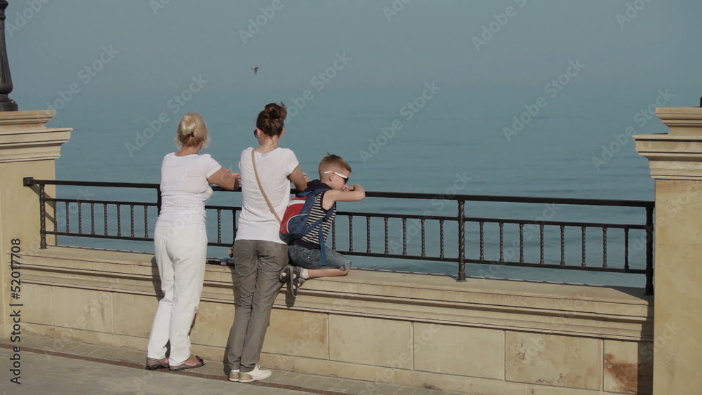family stands on the waterfront and looking at the sea