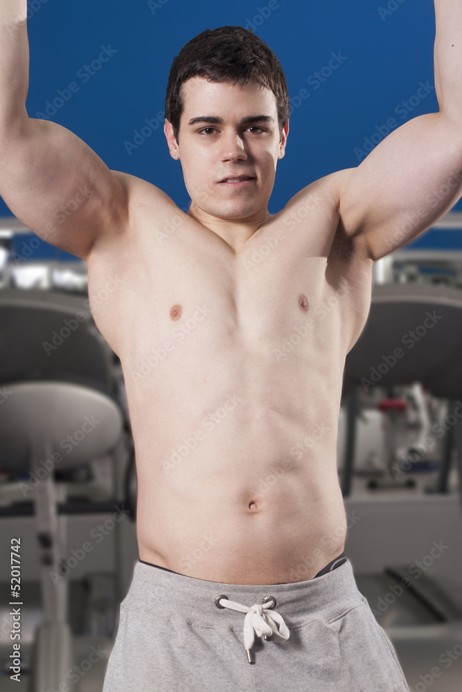 Fototapeta premium Strong handsome man exercising at the gym