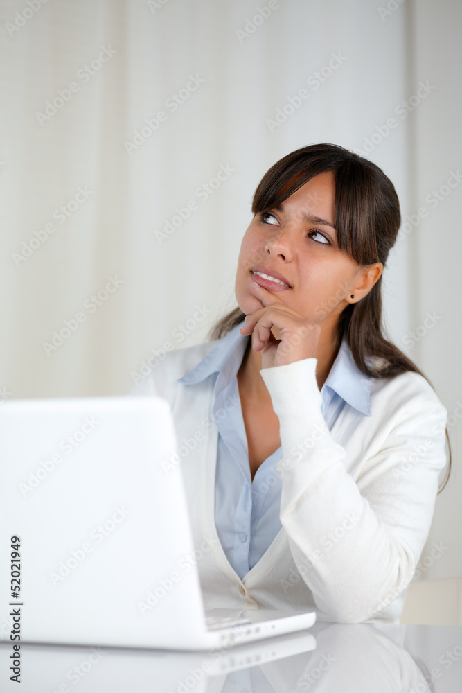 Pensive young woman working on laptop computer Pensive young woman working on laptop computer