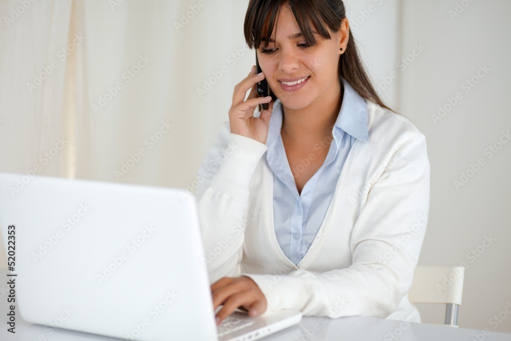 Smiling woman working and speaking on cellphone Smiling woman working and speaking on cellphone