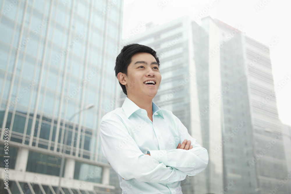 Portrait of young businessman in button down shirt with arms crossed, outdoors, Beijing Portrait of young businessman in button down shirt with arms crossed, outdoors, Beijing