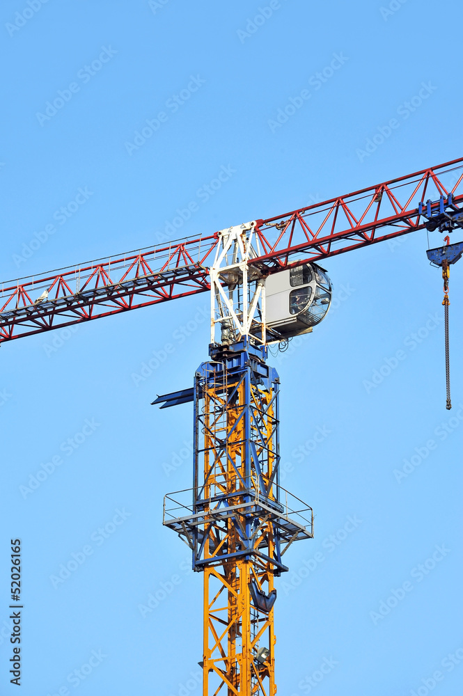 Tall construction tower crane against blue sky Tall construction tower crane against blue sky