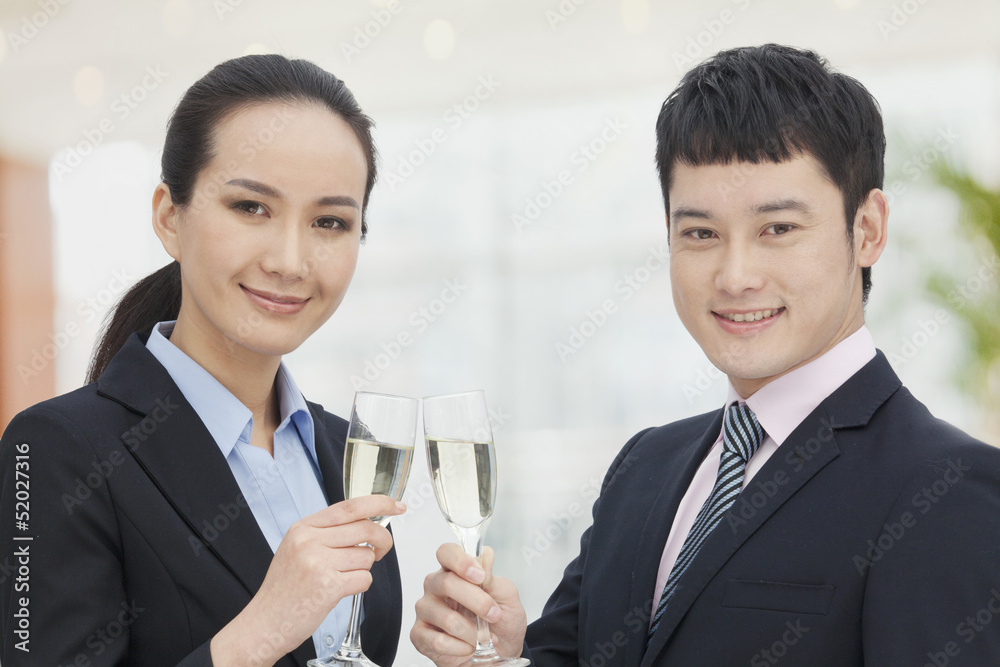 Young business man and woman toasting with champagne flutes Young business man and woman toasting with champagne flutes