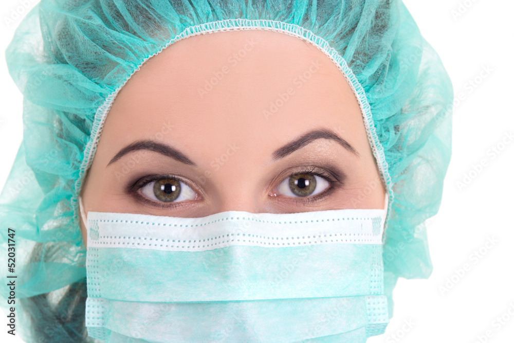 close up portrait of female doctor in blue mask and cap over whi close up portrait of female doctor in blue mask and cap over whi