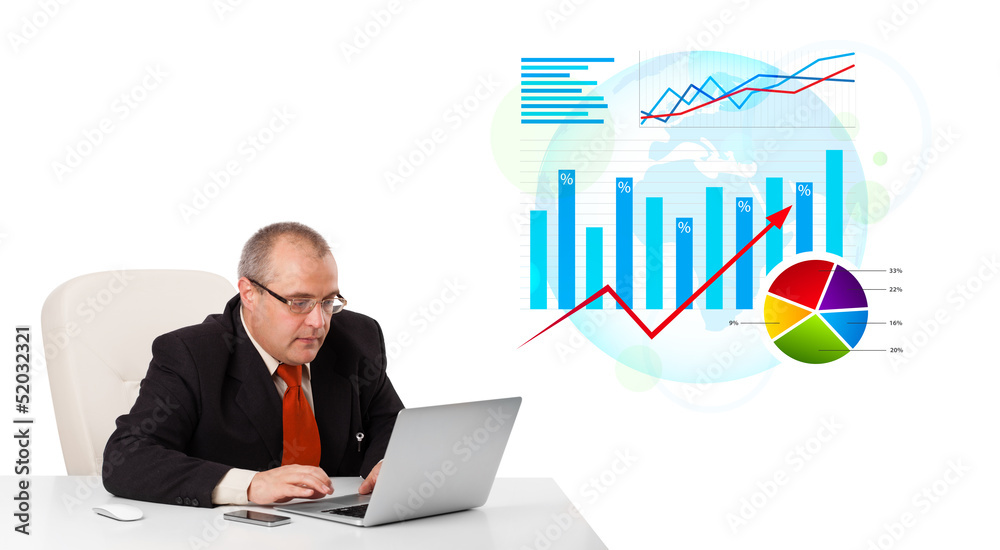 Businessman sitting at desk with laptop and statistics Businessman sitting at desk with laptop and statistics