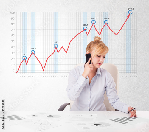 Young businesswoman calculating stock market with rising graph i