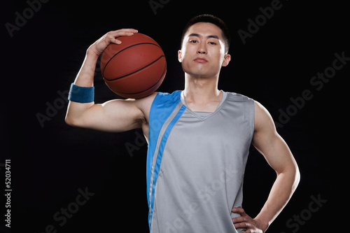 Portrait of basketball player, black background