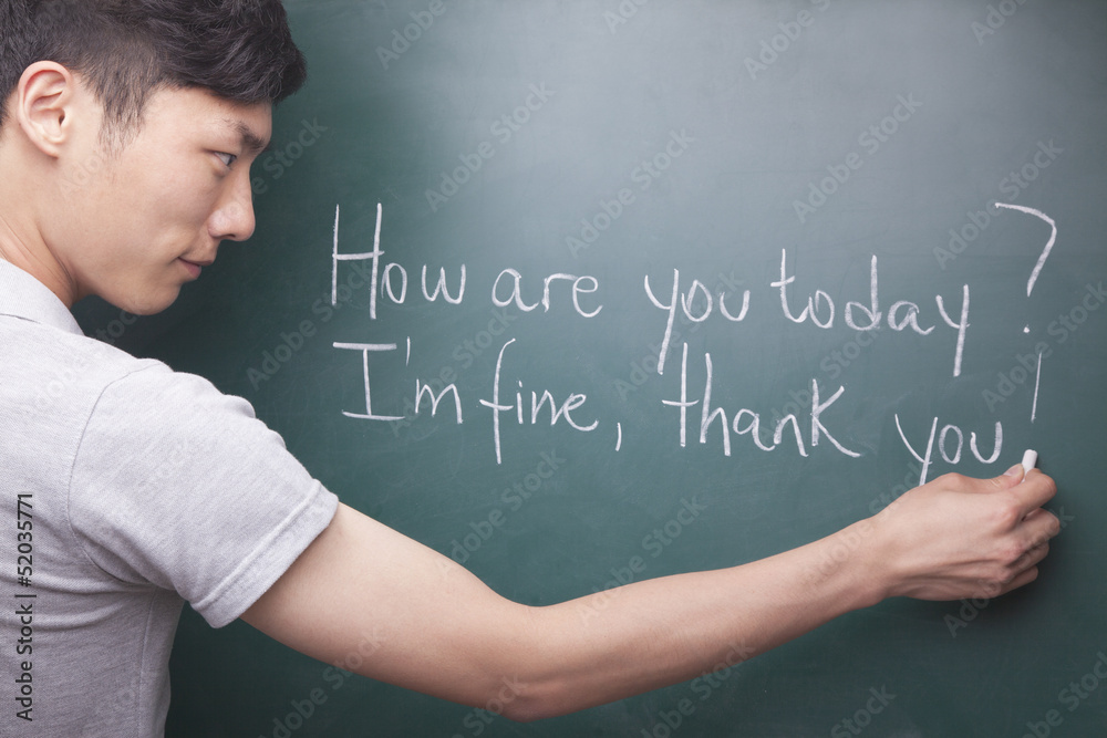 Young man writing English sentences on the blackboard Young man writing English sentences on the blackboard