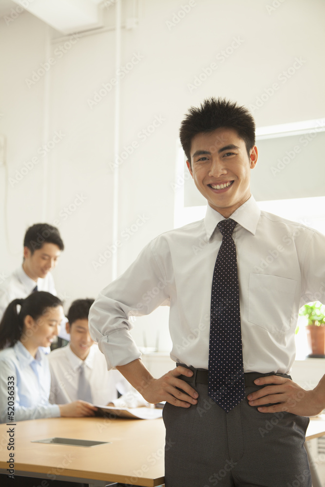 © xixinxing - Young man smiling in the office, portrait