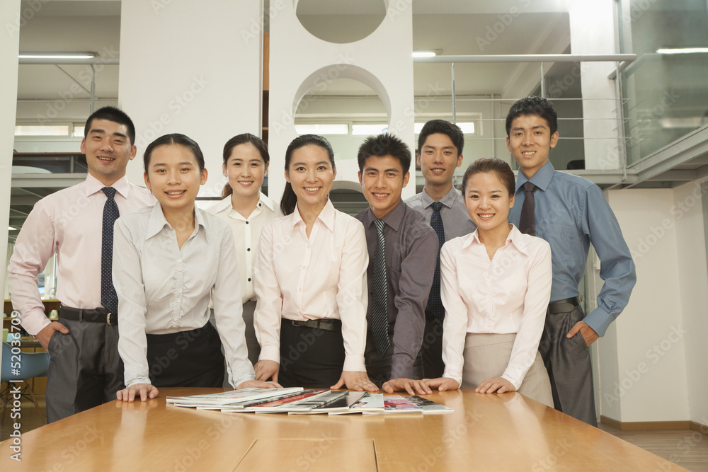 Office team standing near the desk, portrait