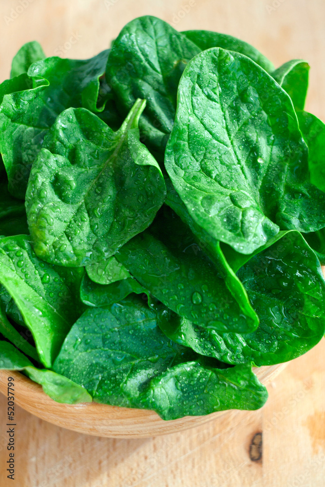 Spinach leaves in a wooden bowl Spinach leaves in a wooden bowl