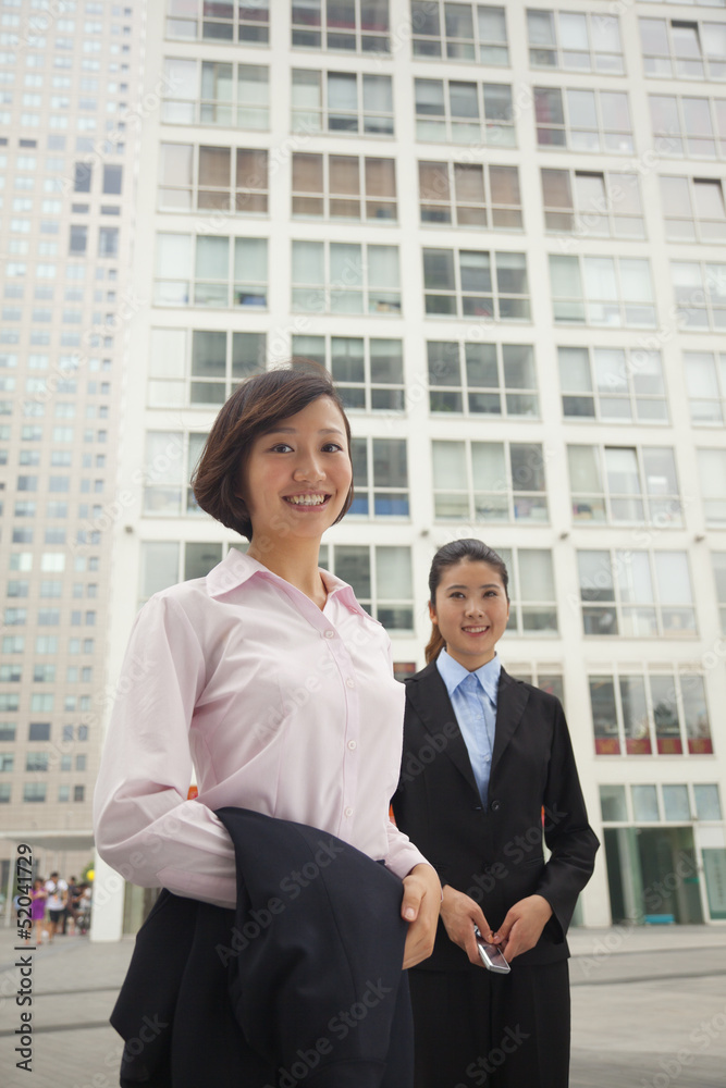Young business women standing outside of CBD, portrait Young business women standing outside of CBD, portrait