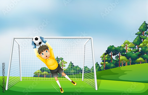 A boy in a yellow uniform catching the ball