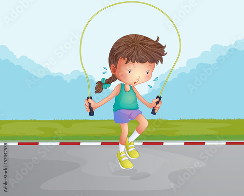 A little girl playing jumping rope at the road