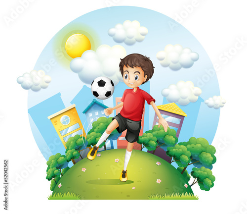 A soccer player practicing near the high buildings