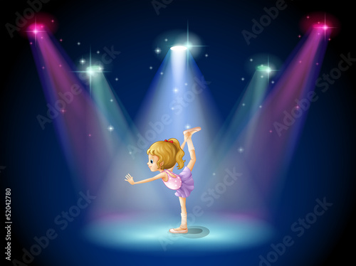 A girl performing ballet on the stage with spotlights