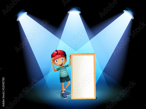 A boy holding an empty frame with spotlights