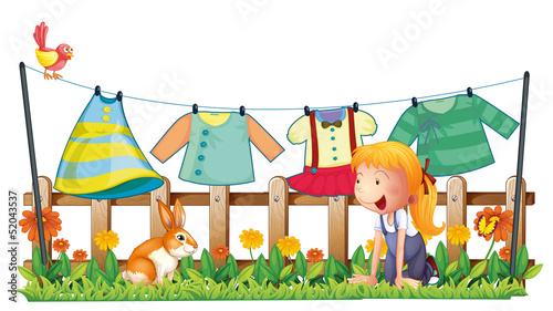 A girl playing with the bunny at the garden with clothes