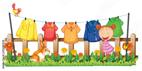 A little girl in the garden with hanging clothes