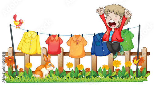 A young boy jumping near the hanging clothes
