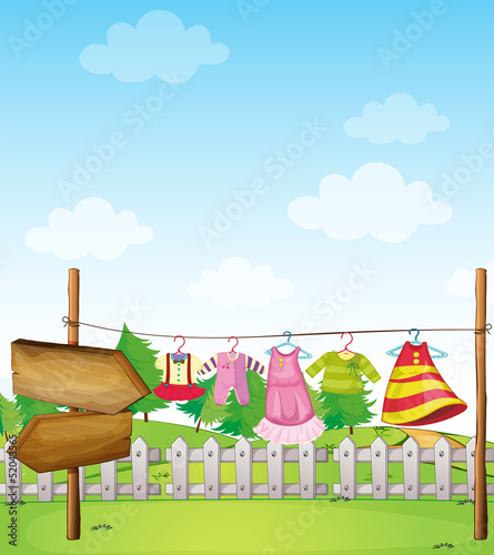 An empty wooden arrowboard near the hanging clothes
