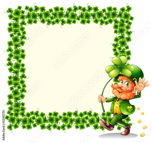 A man holding a clover leaf beside a frame made of leaves