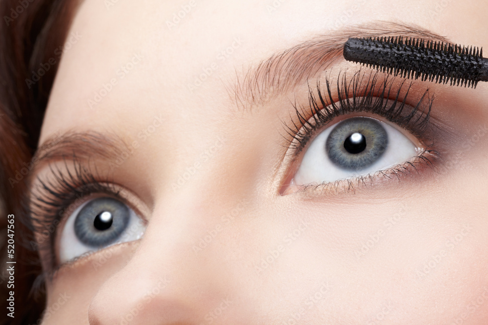 Obraz premium beautiful woman applying mascara