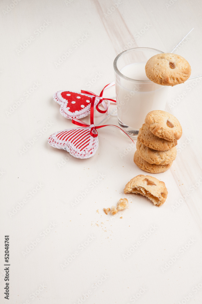 Biscuits on a plate with milk and hearts, breakfast on white bac