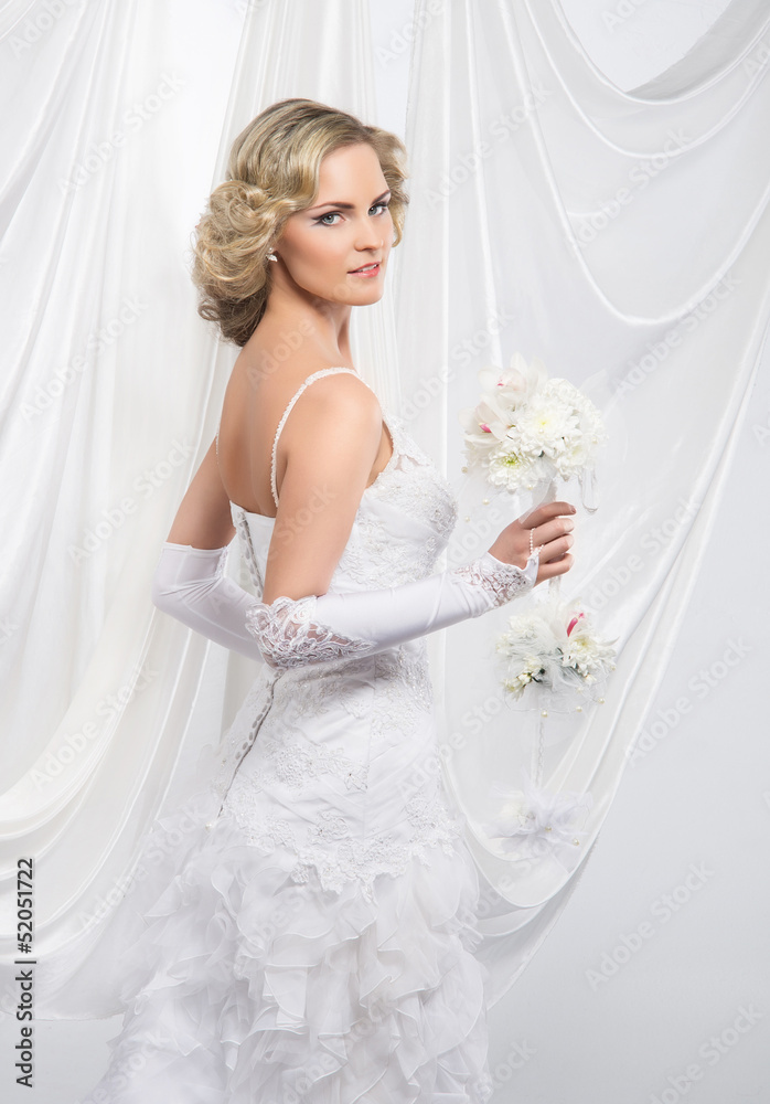 Young and beautiful bride standing with the flower bouquet over Young and beautiful bride standing with the flower bouquet over