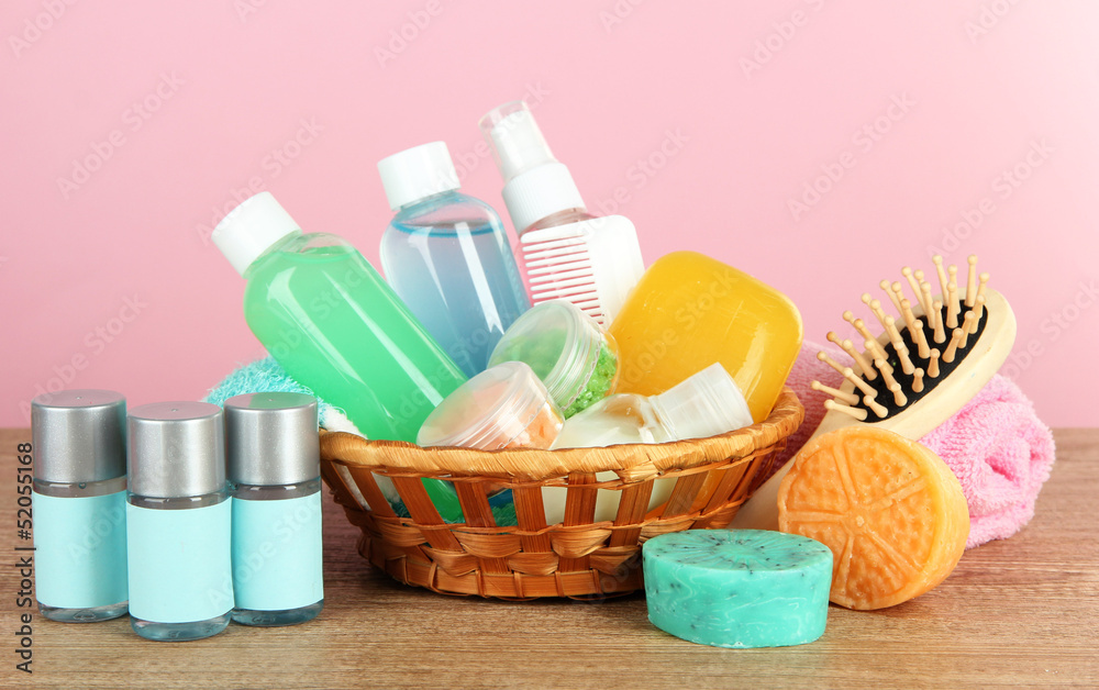 Hotel amenities kit on table on pink background Hotel amenities kit on table on pink background