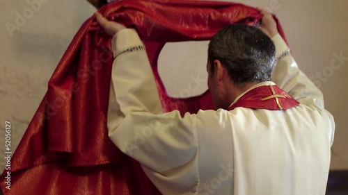 Catholic priest dressing in church before serving mass