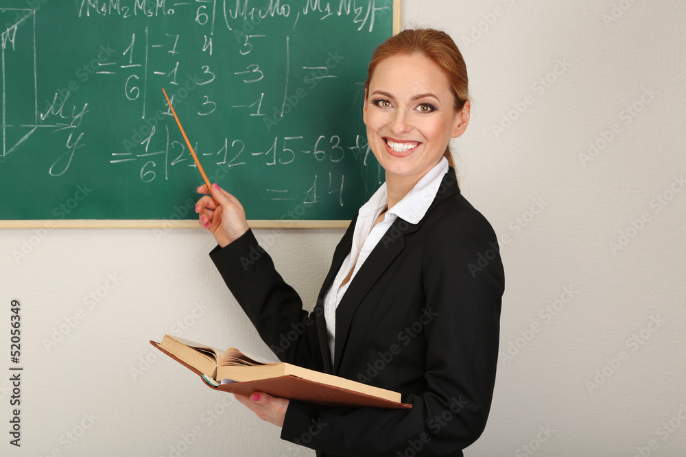 Portrait of teacher woman near the chalkboard in classroom Portrait of teacher woman near the chalkboard in classroom