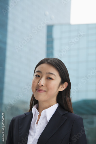 Free Download Portrait of young businesswoman outdoors among skyscrapers - GFXLoad