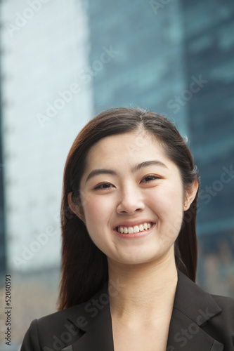 Portrait of young businesswoman outdoors among skyscrapers