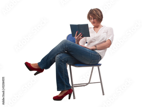 young woman with glasses sitting on chair and reading a book