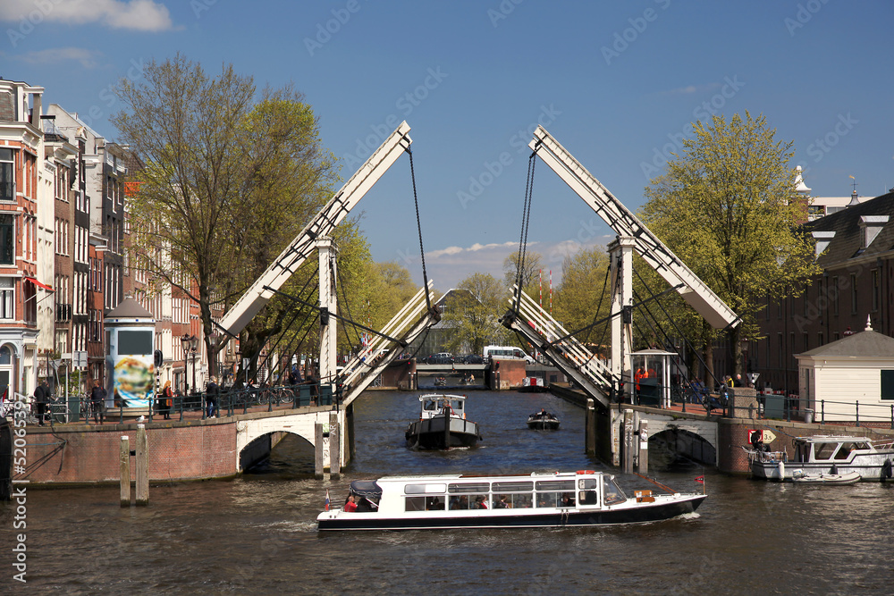 Obraz premium Amsterdam with boat against old bridge in Holland