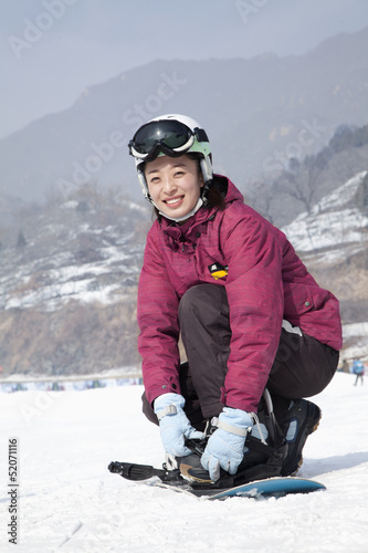 Smiling Woman adjusting Ski Boot in Ski Resort