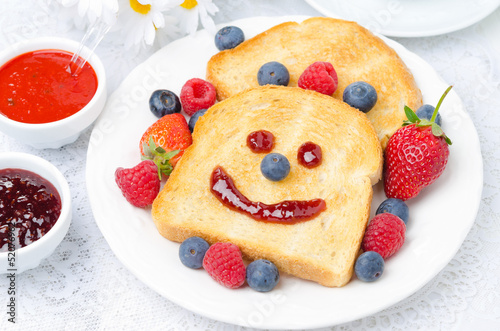 Breakfast with a smiling toast, fresh berries, jams