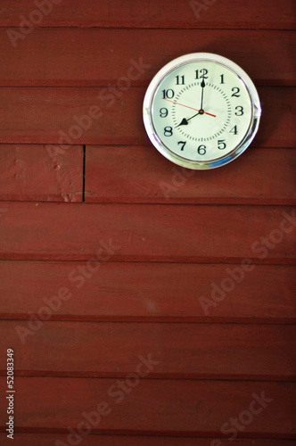 Clock on red wooden wall background