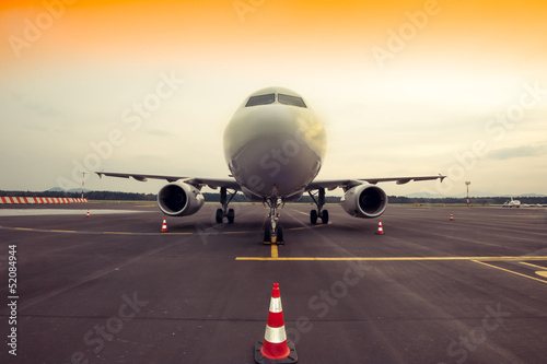 Commercial airplane parking at the airport, with traffic cone in