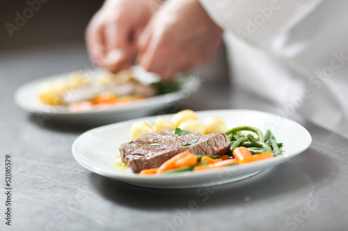 Chef preparing a dish in a kitchen restaurant