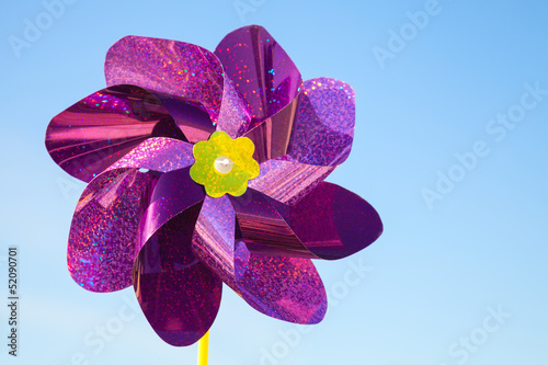 Violet whirligig toy above blue sky photo