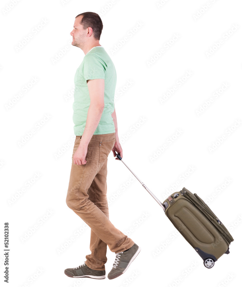 back view of walking man with suitcase. brunette guy in motio back view of walking man with suitcase. brunette guy in motio