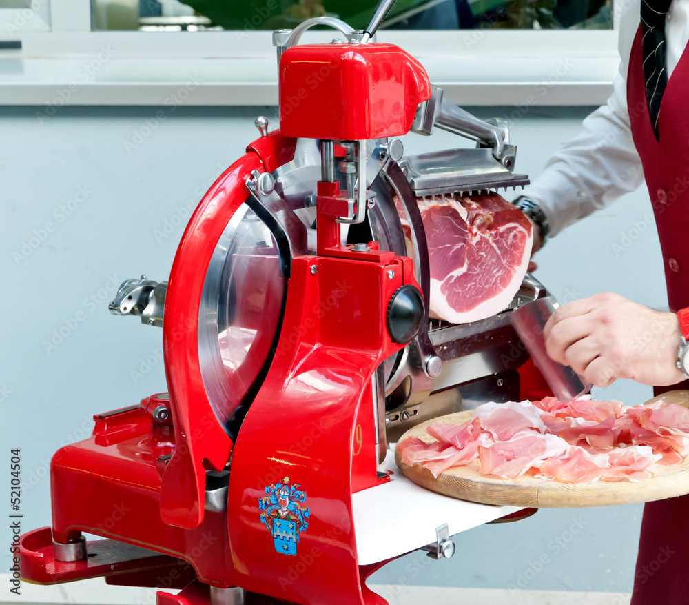 Foto Stock Affettatrice con prosciutto crudo | Adobe Stock